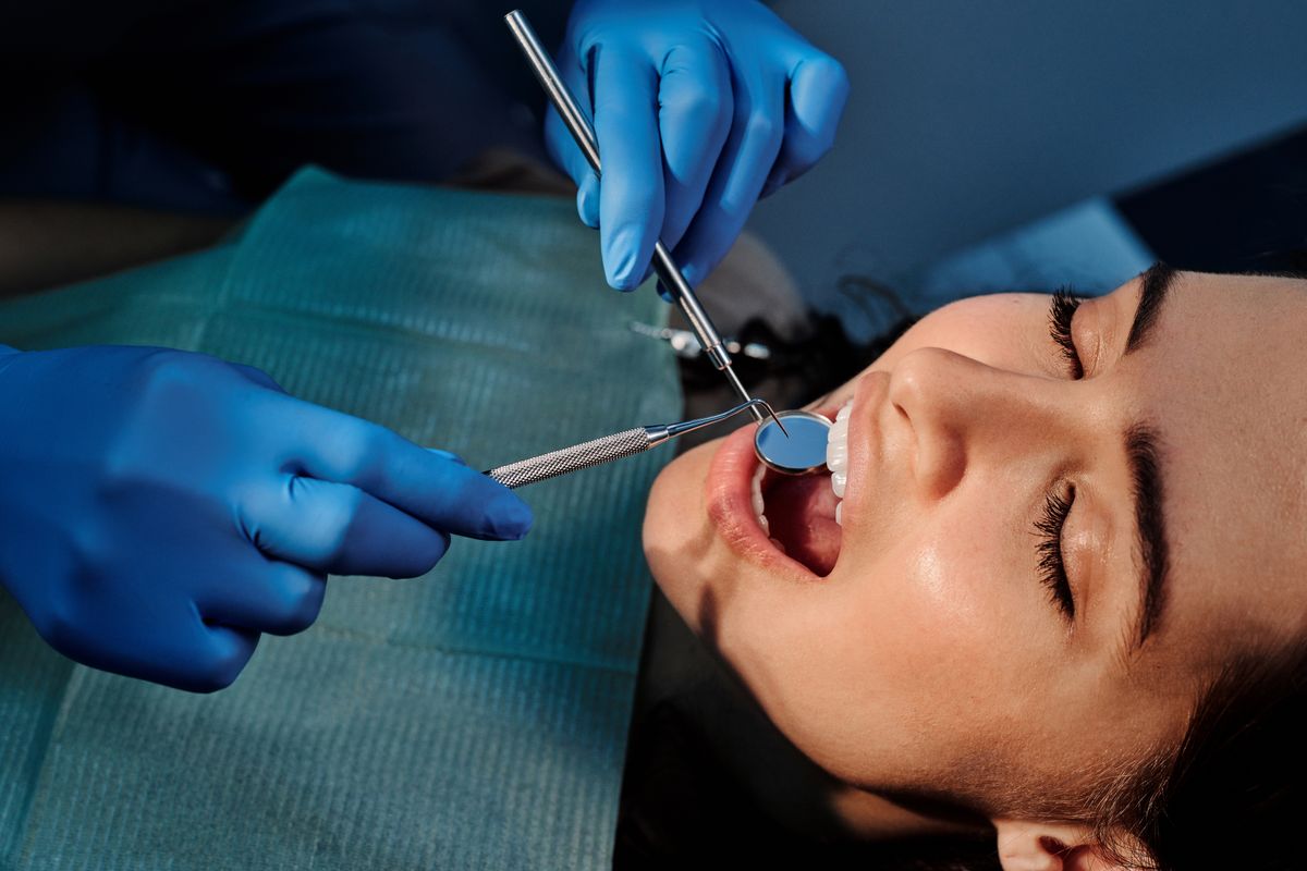 Exploración bucal con espejo dental a una paciente