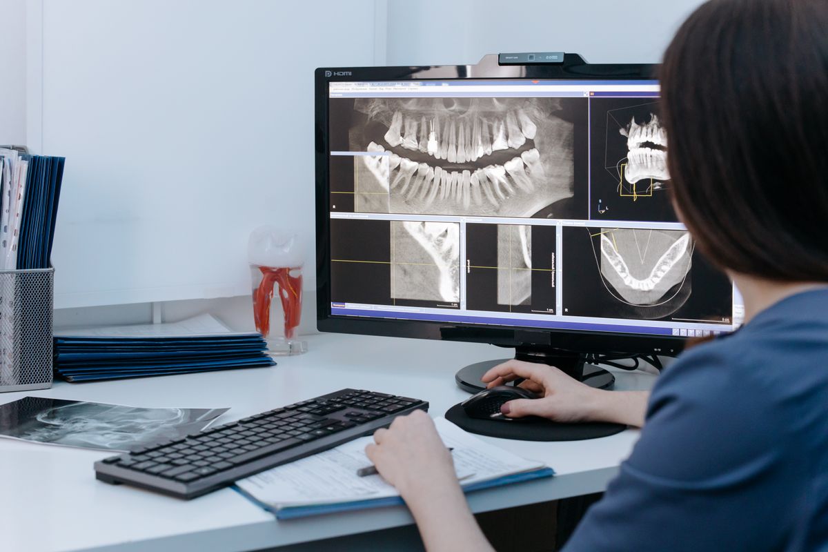 Profesional revisando radiografías dentales en el ordenador